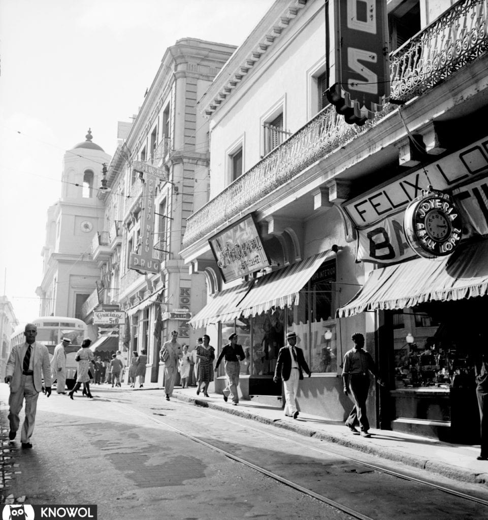 San Juan Puerto Rico Street Scene shows men walking on a street lined with stores. December, 1941.