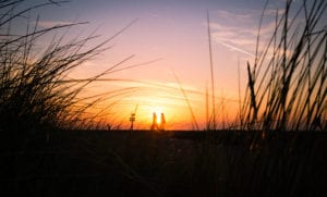 Two people walking forward in sunset