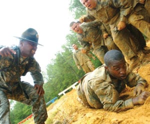 Drill Sgt. Primus Brown instructs Soldiers from B Company, 3rd Battalion, 30th Infantry as they learn to high-crawl through a sand pit as part of an obsticle course on Fort Benning's Sand Hill Tuesday, Oct. 17. The Soldiers are in their fifth day of Basic Training. Photo by David Dismukes