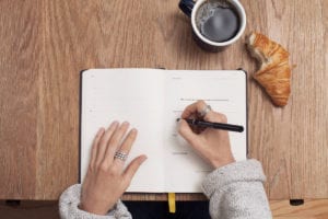 Woman's hands writing in planner