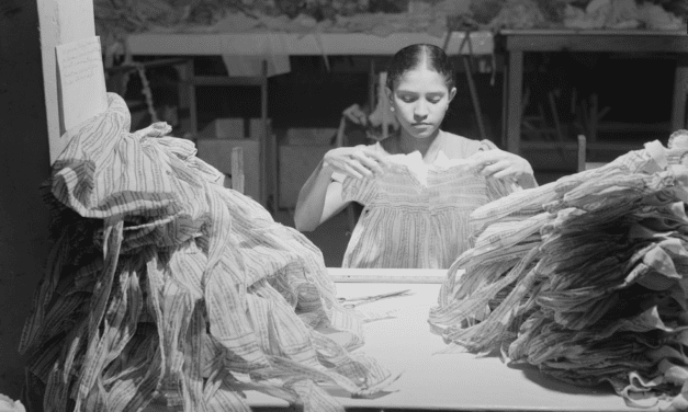 A woman makes dresses in a needlework factory in San Juan