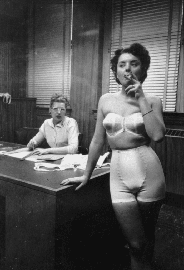 A photograph by Stanley Kubrick depicting a woman smoking a cigarette in an office