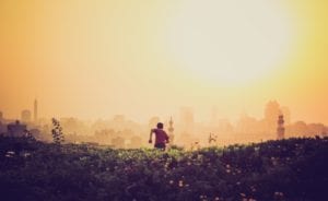 Boy Running Toward a City